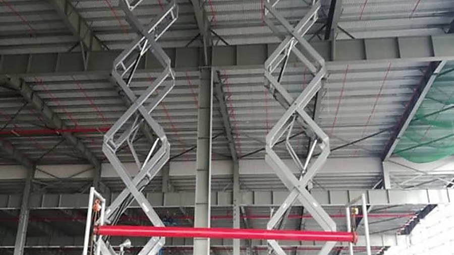 xe nâng người cắt kéo scissor lift trong nhà xưởng công nghiệp